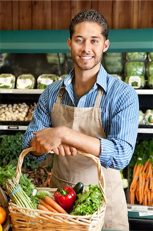 simsearch:693-06120760,k - Portrait de standing beau jeune vendeur avec panier rempli de légumes Photographie de stock - Premium Libres de Droits, Code: 693-06324945