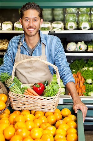 produce in baskets - Portrait of a happy man with vegetable basket standing near oranges stall in supermarket Stock Photo - Premium Royalty-Free, Code: 693-06324947