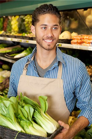 parceiro de vendas - Happy young sales clerk holding bok choy in supermarket Foto de stock - Royalty Free Premium, Número: 693-06324940