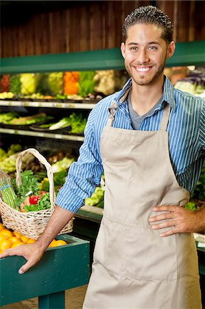 Handsome young sales clerk standing near stall in supermarket Stock Photo - Premium Royalty-Free, Code: 693-06324950