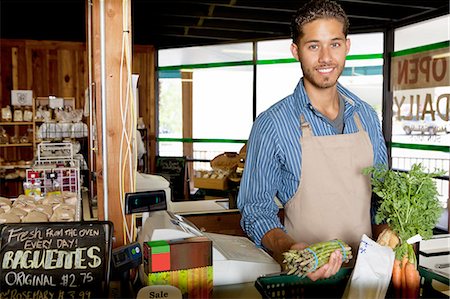 simsearch:693-06120762,k - Portrait of handsome young store clerk holding vegetable in supermarket Fotografie stock - Premium Royalty-Free, Codice: 693-06324952