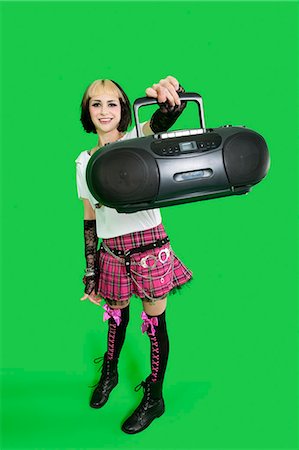 simsearch:693-06324980,k - Portrait of young woman holding boom box over green background Foto de stock - Sin royalties Premium, Código: 693-06324963