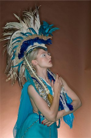 feathers studio - Beautiful woman posing in feathered outfit over colored background Foto de stock - Sin royalties Premium, Código: 693-06325037
