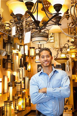 simsearch:693-06325150,k - Portrait of happy handsome man standing with arms crossed in store Fotografie stock - Premium Royalty-Free, Codice: 693-06325155