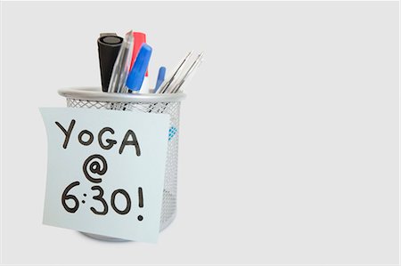 Close-up of sticky note with yoga message on pen holder over white background Stock Photo - Premium Royalty-Free, Code: 693-06325167