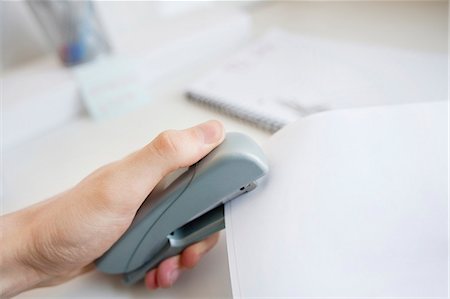 stapler - Close-up of man's hand stapling paper in office Foto de stock - Sin royalties Premium, Código: 693-06325168