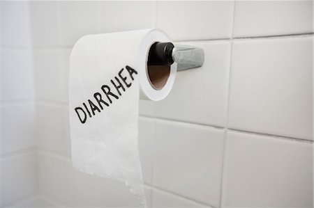 Close-up of toilet paper roll with diarrhea written in bathroom Stock Photo - Premium Royalty-Free, Code: 693-06325178