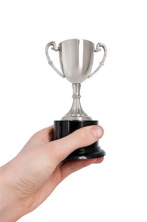 simsearch:693-06325253,k - Cropped image of man's hand holding winning trophy over white background Stock Photo - Premium Royalty-Free, Code: 693-06325209