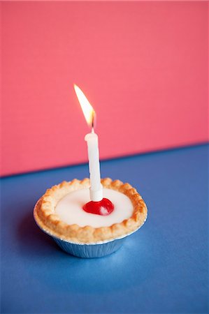 Nahaufnahme der Kerze, die auf Cupcake gegenüber dem farbigen Hintergrund Stockbilder - Premium RF Lizenzfrei, Bildnummer: 693-06325232