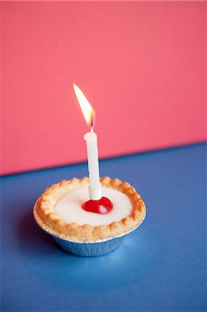 dessert for birthday - Close-up of candle burning on cupcake over colored background Stock Photo - Premium Royalty-Free, Code: 693-06325232