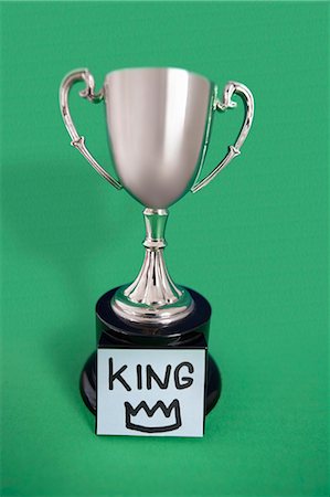 Trophy with sticky note over colored background Stock Photo - Premium Royalty-Free, Code: 693-06325253