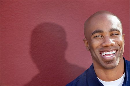 portrait shadow - Portrait of a cheerful African American man over colored background Stock Photo - Premium Royalty-Free, Code: 693-06323981