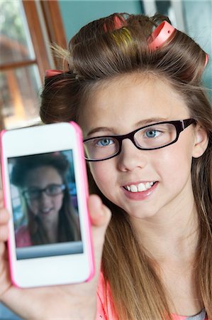 selfie cell phone indoor - Little girl with hair curlers photographing herself with cell phone Stock Photo - Premium Royalty-Free, Code: 693-06378769