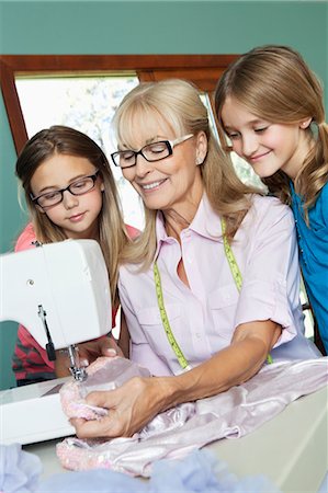 people sewing - Girls looking grandmother sewing cloth Stock Photo - Premium Royalty-Free, Code: 693-06378763