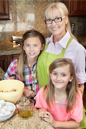 simsearch:693-06378940,k - Portrait of a senior woman with granddaughters in kitchen Fotografie stock - Premium Royalty-Free, Codice: 693-06378773