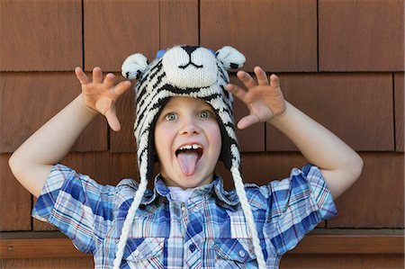 sacando la lengua - Portrait of a little boy sticking out tongue against brick wall Foto de stock - Sin royalties Premium, Código: 693-06378797