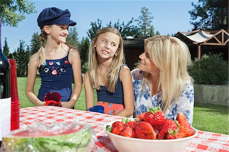 Mother communicating with daughters while sitting at outdoor dining table Stock Photo - Premium Royalty-Free, Code: 693-06378799