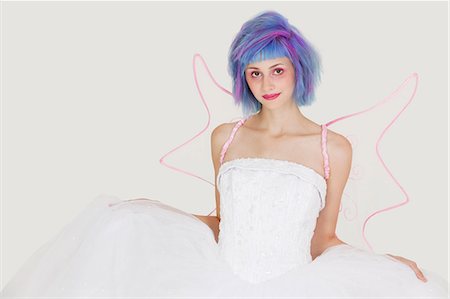 simsearch:693-06378887,k - Portrait of beautiful young woman dressed as angel with dyed hair against gray background Foto de stock - Sin royalties Premium, Código: 693-06378810