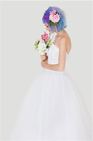 robe de mariée - Vue latérale d'une jeune femme en robe de mariée avec des cheveux colorés sur fond gris Photographie de stock - Premium Libres de Droits, Code: 693-06378828