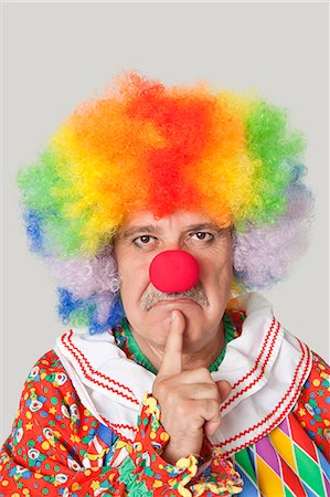 fou - Portrait de colère clown masculin senior avec le doigt sur le menton sur fond gris clair Photographie de stock - Premium Libres de Droits, Code: 693-06378840