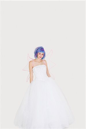 simsearch:693-06378858,k - Portrait of beautiful young woman dressed as angel with dyed hair against gray background Stock Photo - Premium Royalty-Free, Code: 693-06378866