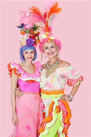 feather isolated - Portrait of happy young and senior women in Brazilian outfits over pink background Stock Photo - Premium Royalty-Free, Code: 693-06378871