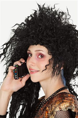 simsearch:693-06378888,k - Beautiful young Goth woman with teased hair using mobile phone Stock Photo - Premium Royalty-Free, Code: 693-06378891