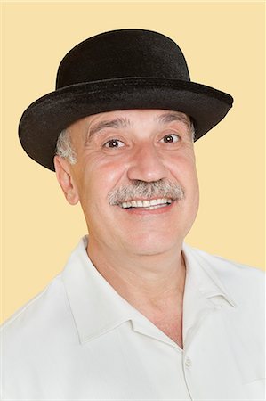 simsearch:693-06378948,k - Portrait of happy senior man with black hat over yellow background Foto de stock - Royalty Free Premium, Número: 693-06378927