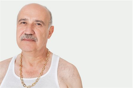 Portrait of senior man with gold chain over gray background Fotografie stock - Premium Royalty-Free, Codice: 693-06378947