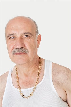 simsearch:693-06378948,k - Portrait of senior man in vest with gold chain over gray background Foto de stock - Royalty Free Premium, Número: 693-06378948