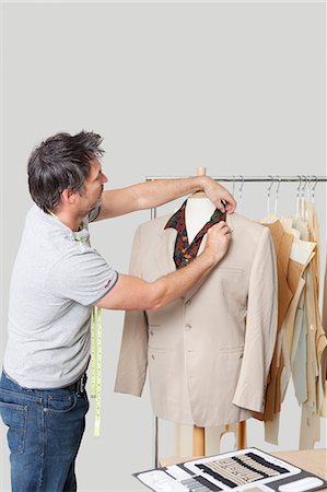 fashion for a 40 year old man - Male dressmaker adjusting suit on tailor's dummy in design studio Stock Photo - Premium Royalty-Free, Code: 693-06379001