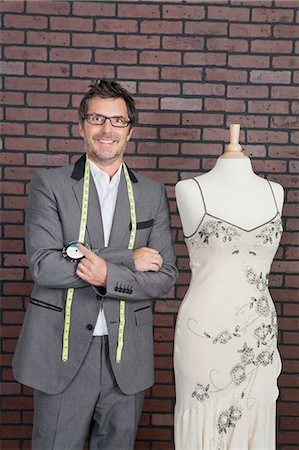 Portrait of mature male fashion designer standing next to tailor's dummy Foto de stock - Sin royalties Premium, Código: 693-06379033