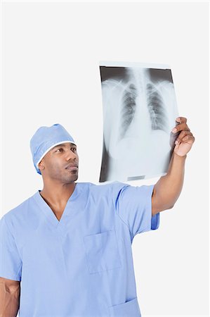 African American male surgeon analyzing x-ray report over gray background Foto de stock - Sin royalties Premium, Código: 693-06379058