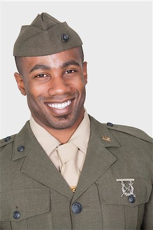 simsearch:693-06379155,k - Portrait of a male, African American soldier smiling, studio shot on gray background Stock Photo - Premium Royalty-Free, Code: 693-06379158