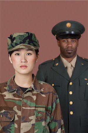 Portrait of young, female soldier with male officer in background Foto de stock - Royalty Free Premium, Número: 693-06379167