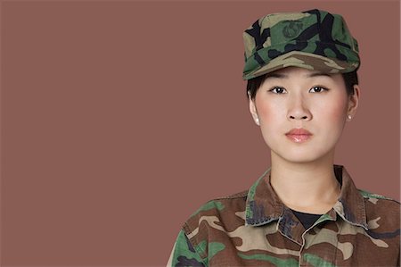 defense - Portrait of young, female soldier, Studio Shot on brown background Stock Photo - Premium Royalty-Free, Code: 693-06379170