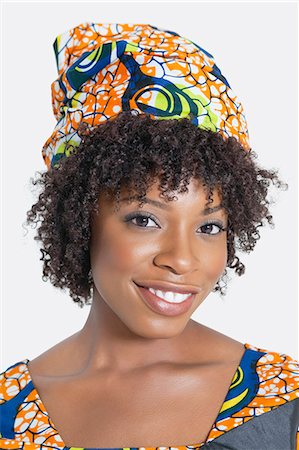 regarder en arrière - Portrait d'une femme afro-américaine souriant sur fond gris Photographie de stock - Premium Libres de Droits, Code: 693-06379229