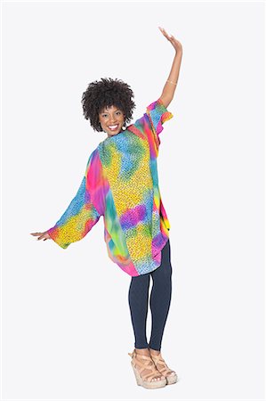 simsearch:693-06324635,k - Full length portrait of happy African American woman in dashiki dancing over gray background Stock Photo - Premium Royalty-Free, Code: 693-06379267