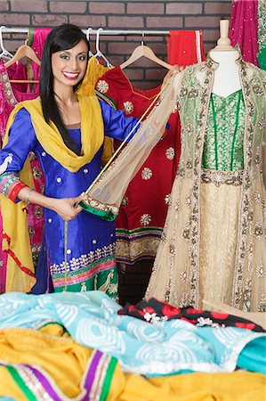 Portrait of Indian designer measuring traditional outfit at design studio Foto de stock - Sin royalties Premium, Código: 693-06379304