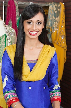simsearch:693-06379304,k - Portrait of an attractive Indian female dressmaker smiling Foto de stock - Royalty Free Premium, Número: 693-06379311