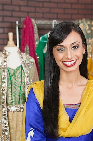 simsearch:693-06379274,k - Portrait of a pretty Indian female dressmaker smiling Fotografie stock - Premium Royalty-Free, Codice: 693-06379312