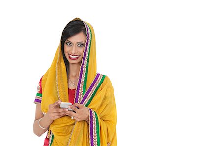 simsearch:693-06435808,k - Portrait de jeune femme indienne en vêtements traditionnels holding cell phone sur fond blanc Photographie de stock - Premium Libres de Droits, Code: 693-06379329