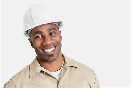 sturzhelm - Porträt von glücklich afrikanischen Bau über mit Bauarbeiterhelm auf grauem Hintergrund Stockbilder - Premium RF Lizenzfrei, Bildnummer: 693-06379323