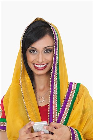 simsearch:693-06435808,k - Portrait d'une femme indienne attrayante en vêtements traditionnels tenant cell phone sur fond blanc Photographie de stock - Premium Libres de Droits, Code: 693-06379330