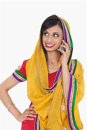 simsearch:693-06435808,k - Femme indienne en vêtements traditionnels répondant à coup de fil sur fond blanc Photographie de stock - Premium Libres de Droits, Code: 693-06379331