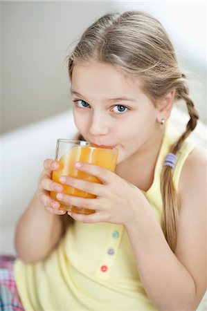 Portrait of little girl drinking orange juice Stock Photo - Premium Royalty-Free, Code: 693-06379395