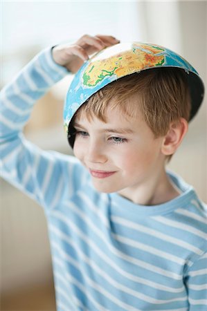 Young boy with map bowl on his head Stock Photo - Premium Royalty-Free, Code: 693-06379410