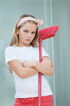 displeased - Portrait of an angry girl with broom Stock Photo - Premium Royalty-Free, Code: 693-06379429