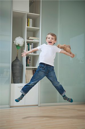 screaming (human yelling) - Portrait of a boy in casuals jumping in mid-air Stock Photo - Premium Royalty-Free, Code: 693-06379445