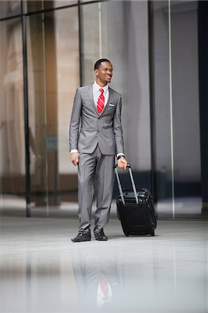 suit full length - Happy male executive with luggage on a business trip Stock Photo - Premium Royalty-Free, Code: 693-06379468